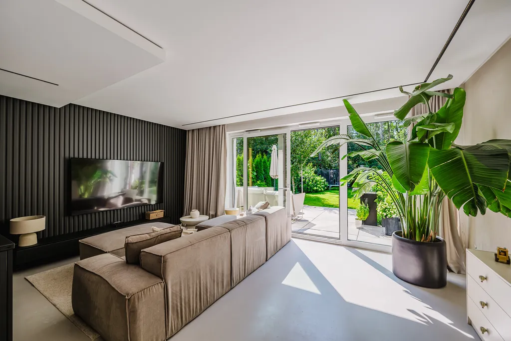 Living room with a dark slat wall and windows onto the garden