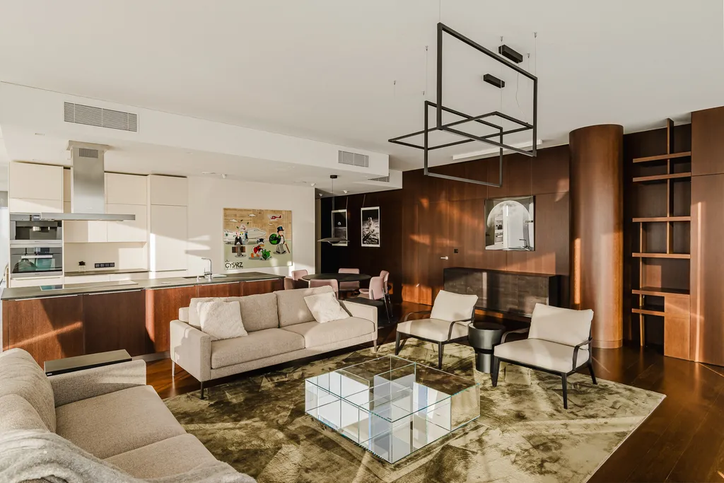 Living room with a rug, glass coffee table and walnut joinery