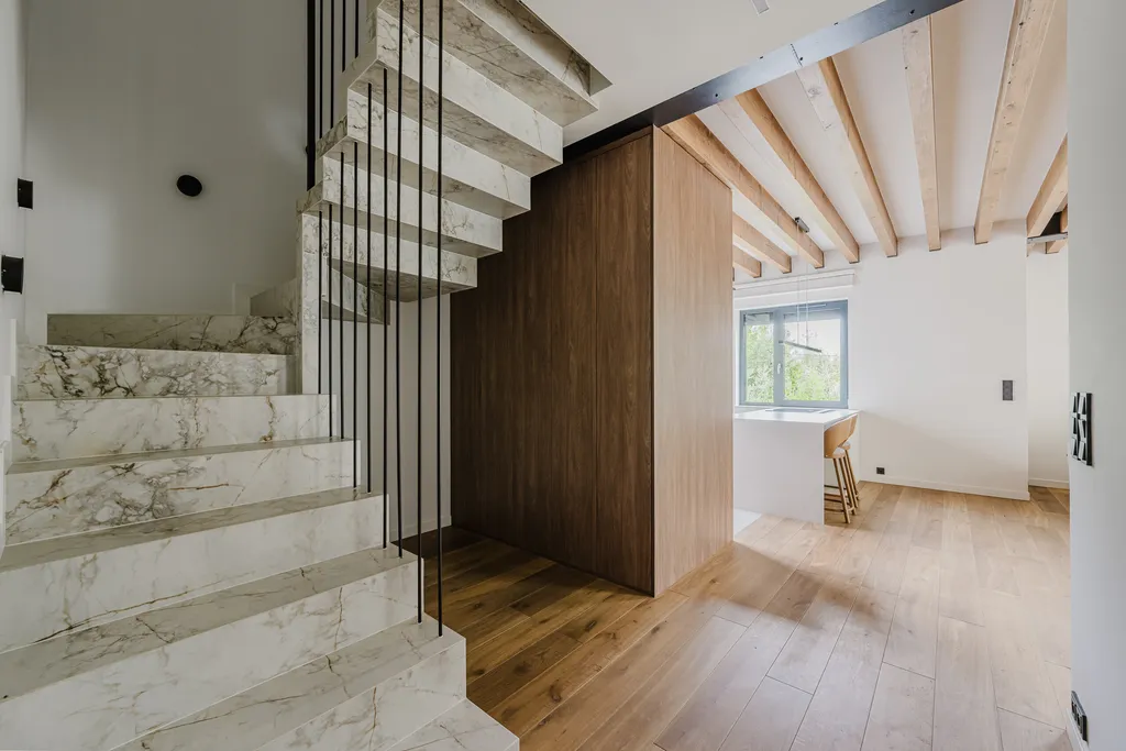 Frame from a house with exposed ceiling beams and marble stairs