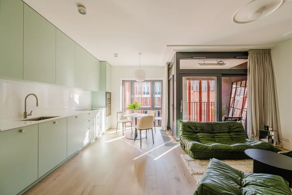 Frame from an apartment with a green sofa and a mint kitchen