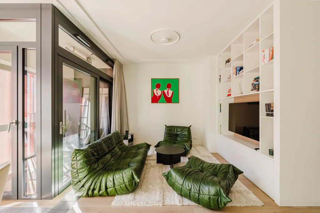 Frame from an apartment with a green sofa and a mint kitchen