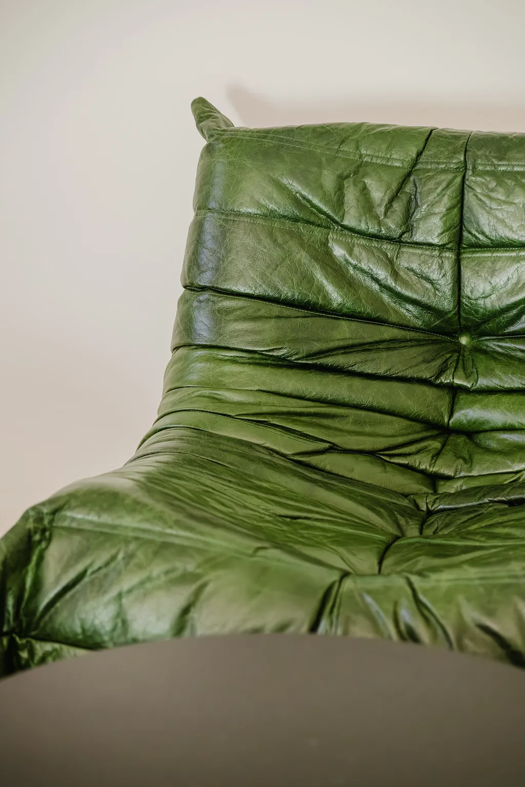 Detail from an apartment with a green sofa and a mint kitchen